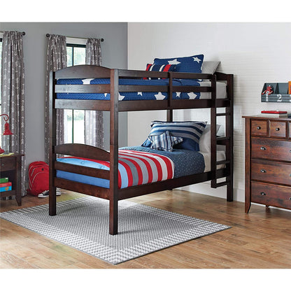 A brown wooden bunk bed with a ladder, featuring a lower bed with a blue mattress and a upper bed with a red and blue striped mattress. 